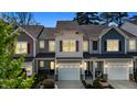 Dusk view of a townhouse with an attached garage and inviting exterior lighting at 124 Myatt Fern Dr, Garner, NC 27529