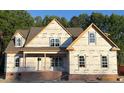 New construction home featuring prominent windows, brick foundation, and protective house wrap for weather resistance at 1589 S Old Carriage Rd, Rocky Mount, NC 27804
