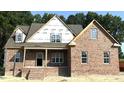 New two-story brick home under construction with a covered porch and visible framing at 1589 S Old Carriage Rd, Rocky Mount, NC 27804