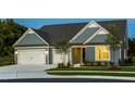Charming curb appeal with blue siding, a manicured lawn, and convenient two-car garage at 1601 Garden Park Cir, Fuquay Varina, NC 27526