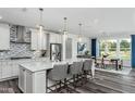 Modern kitchen featuring a large island with seating, stainless steel appliances, and a stylish backsplash at 1601 Garden Park Cir, Fuquay Varina, NC 27526
