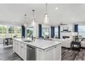 Open-concept kitchen showcasing a spacious island, stainless steel appliances, and seamless flow to the living area at 1601 Garden Park Cir, Fuquay Varina, NC 27526
