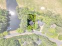 Aerial view of the house and its lot surrounded by trees, a pond and a golf course at 1913 Wild Dunes Dr, Raleigh, NC 27604