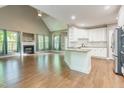 Open-concept living space with fireplace, large windows, and modern kitchen at 216 Billingrath Turn Ln, Cary, NC 27519
