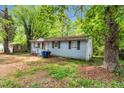 View of the exterior of a single-story home with light blue siding and black shutters surrounded by trees at 2733 Thelma St, Durham, NC 27704
