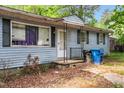 Close up of the front exterior featuring a blue home with black shutters and front porch entrance at 2733 Thelma St, Durham, NC 27704