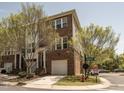 Exterior view of a brick townhome with a one car garage and professional landscaping at 3000 Summerhouse Rd, Cary, NC 27519