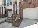 Charming brick townhome showcasing a private entrance with a well-kept one car garage at 3000 Summerhouse Rd, Cary, NC 27519
