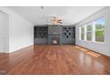 Cozy living room featuring a fireplace, built-in shelving, hardwood floors and large windows at 311 Windrush Ln, Durham, NC 27703