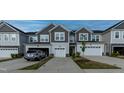 A view of multiple townhomes with attached garages and well-maintained lawns at 313 Kineton Woods Way Way, Garner, NC 27529