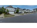 A wide street view of a well-planned neighborhood with sidewalks and street parking at 313 Kineton Woods Way Way, Garner, NC 27529