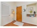 Inviting entryway with a wooden door, coat closet, stylish decor, and hardwood flooring at 3210 Environ Way, Chapel Hill, NC 27517
