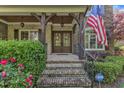 Inviting front entrance featuring double doors, stone steps, wood columns, and lovely landscaping at 3824 Laurel Hills Rd, Raleigh, NC 27612