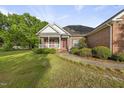 Charming brick home with a covered front porch and well-maintained lawn at 406 N Wakefield St, Zebulon, NC 27597