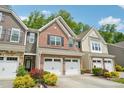 View of townhomes showcasing brick and siding exteriors with attached garages at 409 Summit Trail Dr, Hillsborough, NC 27278
