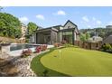 Lush backyard featuring a pool, putting green, and well-maintained landscaping at 4139 Rockingham Dr, Raleigh, NC 27609
