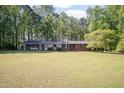 Inviting brick home with a large, verdant front yard surrounded by lush, mature trees at 449 Hill Rd, Franklinton, NC 27525