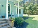Inviting front porch with a rocking chair, colorful flowers, and charming details enhance the exterior view at 4793 Overhills Rd, Spring Lake, NC 28390