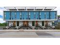 Modern townhome exterior featuring a blue facade, large windows, and private entrances with staircases at 501 S Bloodworth St # 101, Raleigh, NC 27601
