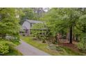 Exterior of home surrounded by mature trees, long driveway, and an American flag in the front yard at 5632 Falkirk Dr, Durham, NC 27712