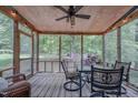 Relaxing screened porch with ceiling fan, string lights, and wooded views offers space for outdoor dining at 5632 Falkirk Dr, Durham, NC 27712