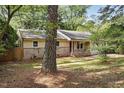 Cozy one-story home with brick accents, surrounded by mature trees and a lush front yard at 5805 Farm Gate Rd, Raleigh, NC 27606