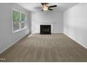 A bright living room features a fireplace and large windows, providing natural light and a cozy atmosphere at 6005 Antigua, Knightdale, NC 27545