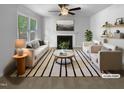 Bright, staged living room with fireplace, ceiling fan and plush white furniture, offering a cozy and inviting space at 6005 Antigua, Knightdale, NC 27545
