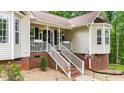 Inviting front porch with white railings, decorated with hanging flower baskets and decor at 6204 Silver Spring Ct, Willow Springs, NC 27592