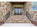 Stone steps lead to the double front doors, complemented by stone and decorative lanterns at 628 Carolina Crossings Dr, Apex, NC 27523