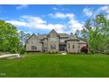 Two-story stone and brick home featuring a manicured front yard and well maintained landscaping at 628 Carolina Crossings Dr, Apex, NC 27523
