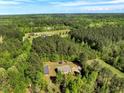 Expansive aerial view showcasing the home nestled among lush greenery and surrounding wooded areas at 7030 Shep Royster Rd, Oxford, NC 27565
