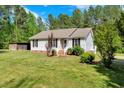 Beautiful house with black shutters, green lawn, and trees, offering a serene, countryside-like feel at 7030 Shep Royster Rd, Oxford, NC 27565