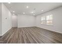 Empty living room features hard surface floors and plenty of natural light, offering a versatile space at 721 Denburn Pl, Raleigh, NC 27603