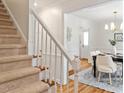 Inviting entryway with staircase and dining area with hardwood floors, creating a warm and elegant ambiance at 8504 Boot Ct, Raleigh, NC 27615