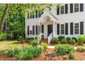 Beautiful home featuring a charming front porch, mature landscaping, and a cozy bench at 8504 Boot Ct, Raleigh, NC 27615