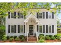 Two-story traditional home with a covered front porch, brick steps, and manicured landscaping at 8504 Boot Ct, Raleigh, NC 27615
