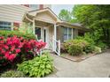 Townhouse entrance with lush landscaping and a covered entryway with white railings at 942 S Fifth St, Mebane, NC 27302