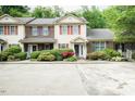 View of a townhome featuring an ample concrete parking area with landscaped shrubbery at 942 S Fifth St, Mebane, NC 27302