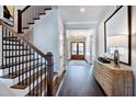 Welcoming entryway with wood stairs, a stylish hall table, and a clear view to the home office at 1 Deer Run Trl, Hillsborough, NC 27278