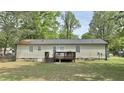 Rear view of the home showcasing a cozy wooden deck overlooking the expansive backyard at 1011 Wyldewood Rd, Durham, NC 27704