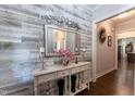 A decorative entryway with a mirror, console table and wood accent wall at 1013 Chelsea Run Ln, Apex, NC 27502