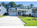 Charming home with a well-manicured lawn, front porch, and two-car garage at 1013 Chelsea Run Ln, Apex, NC 27502