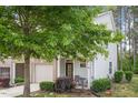 Beautiful townhouse with well-kept landscaping, a front porch sitting area, and an attached garage at 11 Grifton Pl, Durham, NC 27704