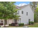 Well-maintained townhouse featuring an attached garage, landscaping, and a front porch seating area at 11 Grifton Pl, Durham, NC 27704