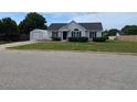 Charming single-story home with a well-manicured lawn, black shutters, and a detached garage at 111 Shadow Bend Ln, Selma, NC 27576
