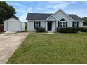 Charming single-story home with a well-manicured lawn, black shutters, and a detached garage at 111 Shadow Bend Ln, Selma, NC 27576