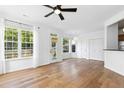 Airy living room features hardwood floors, white walls, and many windows at 1121 Silky Dogwood Trl, Apex, NC 27502