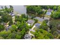 Aerial view of a house with lush green trees, a long driveway, and a body of water at 118 Duncansby Ct, Cary, NC 27511