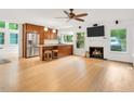 Open-concept living room with a fireplace, hardwood floors, and stainless steel kitchen appliances at 121 Ladybug Ln, Chapel Hill, NC 27516